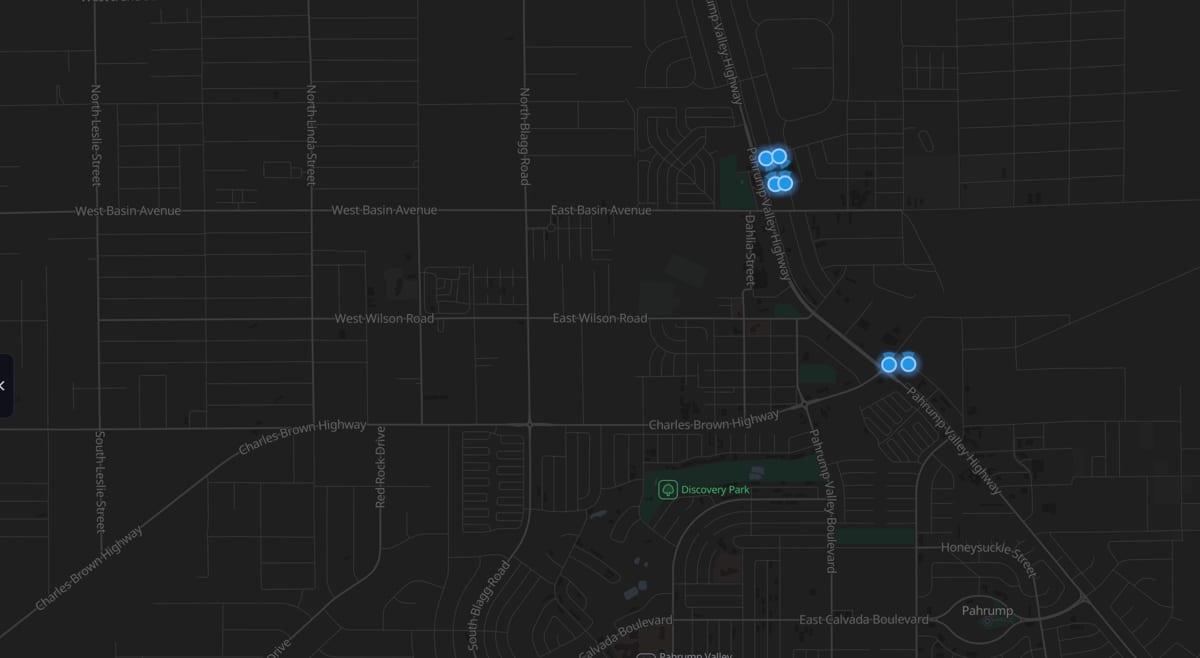 A dark street map of central Pahrump with six glowing blue markers: four clustered at the Home Depot beside Highway 160, and two on their own about a mile south.